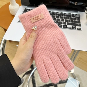 Detail of pink knitted glove featuring soft mohair texture and leather fashion label