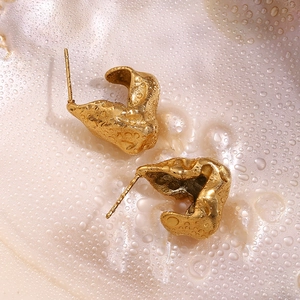 Macro shot of 18K gold plated hammered texture earrings with dew drops on pearl background