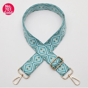 Detail of adjustable woven bag strap with geometric diamond patterns and gold hooks