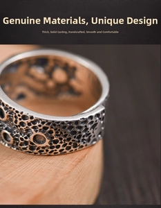 Macro view of wide silver ring featuring crater texture and retro oxidized finish