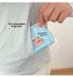 Detail of Capybara mini coin purse being placed into a pocket for portable storage