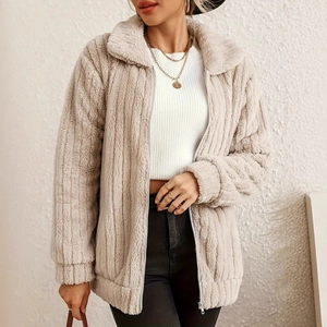 Detail of a beige plush jacket featuring a metal zipper and stand-up collar design