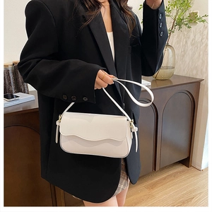 Detail view of a white minimalist shoulder bag featuring a stylish flap design and PU leather