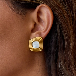 Luxury gold square resin stud earrings with pearlescent white inlay worn by model