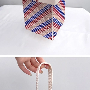 Detailed view of striped rhinestone evening bag with red and blue diagonal patterns