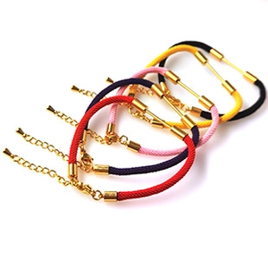 Dettaglio di braccialetti in corda intrecciata colorata con chiusure in metallo dorato