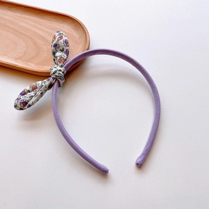 Detailed view of purple floral bow headband for girls featuring soft cotton fabric design