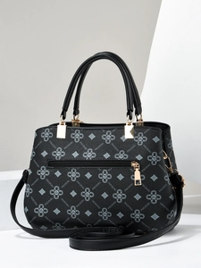 Detail of black tote bag with gold zipper pocket and clover pattern printing