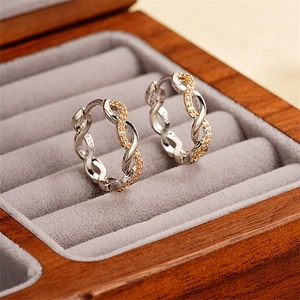 Detailed macro of S925 silver twist earrings with gold accents and sparkling cubic zirconia