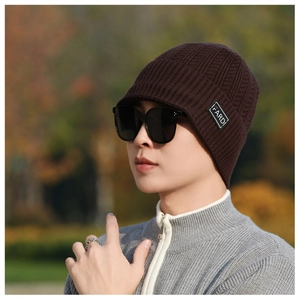 Detail of dark brown cable knit brimmed beanie featuring FARDI textile patch and thick texture