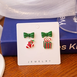 Detail view of asymmetric Christmas earrings with red stocking and striped gift box designs