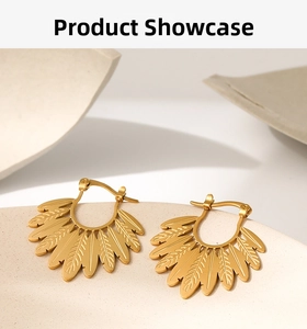 Detailed close-up of layered golden leaf earrings with a textured feather design