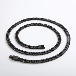 Detailed view of a coiled black stainless steel curb chain with square buckle clasp