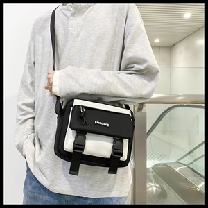 Detail view of the black and white crossbody bag with dual buckle closure and adjustable strap