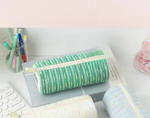 Detail of soft knit stationery pouches with zippers in green, white, and blue colors