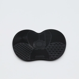 Detail of black silicone brush cleaning mat featuring diverse surface textures for washing