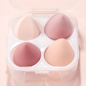 Detail of four teardrop-shaped makeup sponges in a clear dustproof storage box