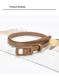 Detail of a slim brown leather belt with a matching rectangular buckle on fashion magazines