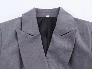 Détail du revers en pointe et de la texture sergée d'un blazer croisé gris