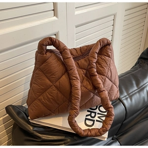 Detail of the chocolate brown quilted tote bag showing its puffer fabric and texture