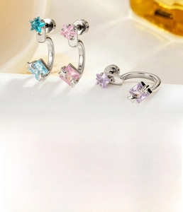 Detail view of C-shape piercing studs with star motif and square zircon in three colors