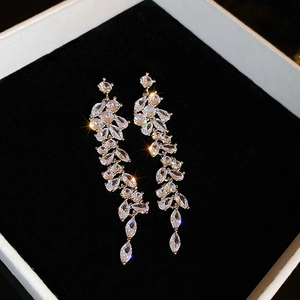 Macro shot of silver snowflake drop earrings with marquise-cut zircons on black velvet