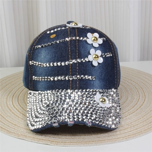 Detailed close-up of denim baseball cap with silver rhinestones and white floral patches
