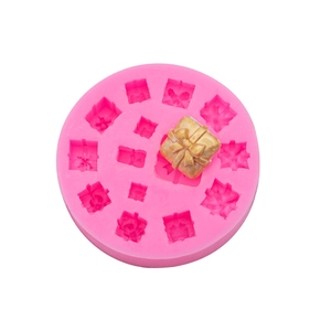 Pink silicone mold for gift box shaped fondant decorations with a gold finished example