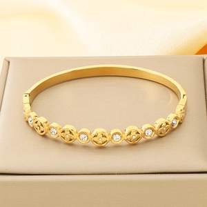 Detail eines 18K vergoldeten Armreifs mit Blumenmuster und Zirkonias in Geschenkbox
