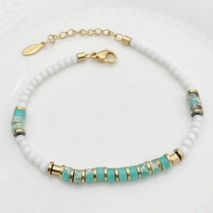 Close-up of beaded bracelet with white beads, cyan stones, and s.steel tag details