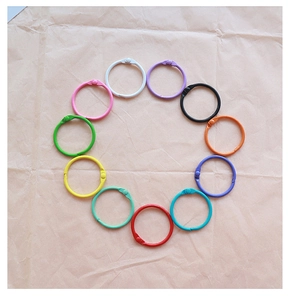 Top view of colorful painted metal binder rings arranged in a circle on kraft paper