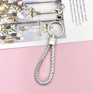 Detailed close-up of a silver braided leather keychain with metal lobster clasp and ring