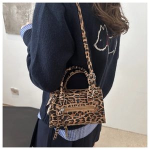 Dettaglio della borsa leopardata con trama in pelle, doppi manici e nappa zip