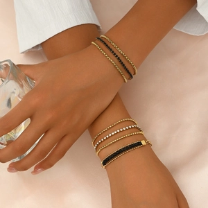 Layered gold stainless steel bracelet set with black and white diamonds on pink silk