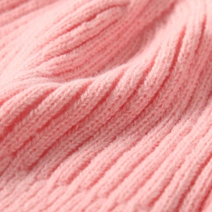 Detailed macro view of pink knit wool fabric showing soft texture and ribbed patterns