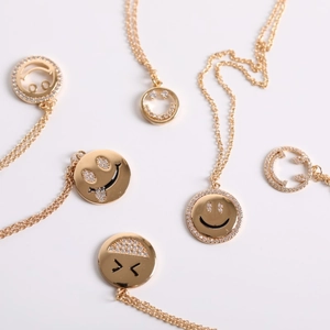 Gold smile pendant necklace with sparkling micro-pave crystals on white background
