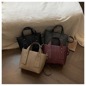 Macro shot of stylish leather tote bags in four trendy colors with gold metal rivets