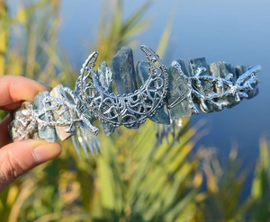 Detail of blue raw stone tiara featuring an ornate silver moon and metallic branch accents