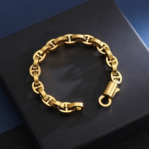 Close-up of golden geometric pig nose chain bracelet on a dark matte jewelry box