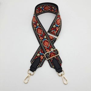 Detail of adjustable canvas bag strap with colorful ethnic embroidery and gold metal hooks