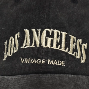 Close-up of Los Angeles vintage embroidery on washed black cotton baseball cap