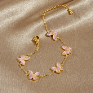 Bracelet papillon élégant plaqué or avec émail scintillant rose et violet sur fond de soie
