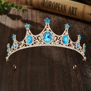 Detailed shot of golden crown with blue and clear rhinestones on vintage book