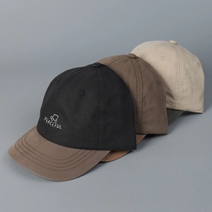 Detailed view of color-block baseball caps with Peaceful embroidery and cotton texture