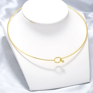 Minimalist gold stainless steel torque necklace displayed on a white neck bust stand