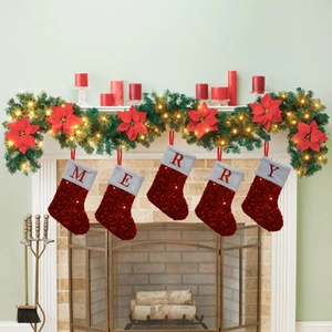 Detailed view of red sequin Christmas stockings with MERRY lettering hanging on a fireplace
