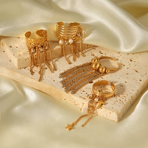 Detail of four gold-plated chain tassel rings with pearls and star cross charms