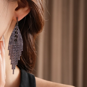 Close-up of elegant lavender purple tassel earrings with long vertical rhinestone fringe