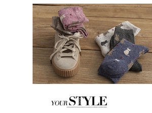 Detailed knit texture of vintage wool crew socks featuring cute cat patterns and flecked yarn