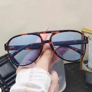 Detail view of tortoiseshell aviator sunglasses with dual-bridge and light blue lenses